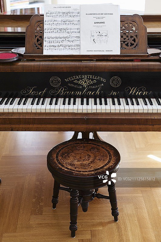 三角钢琴和古董凳子上的乐谱图片素材