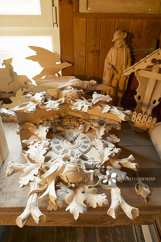 精美的布谷鸟钟和工作台上的其他雕刻品图片素材