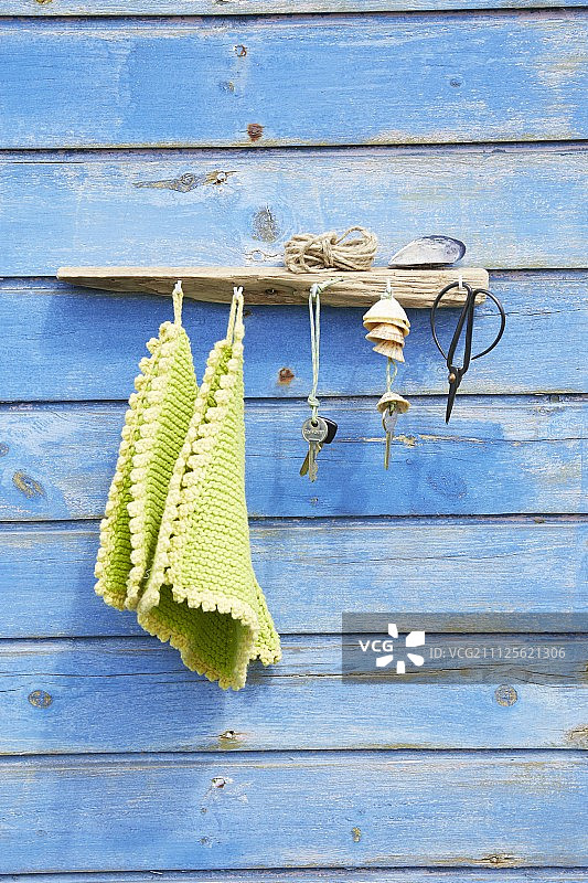 用漂流木制成的衣帽架，安装在蓝色木板墙上图片素材