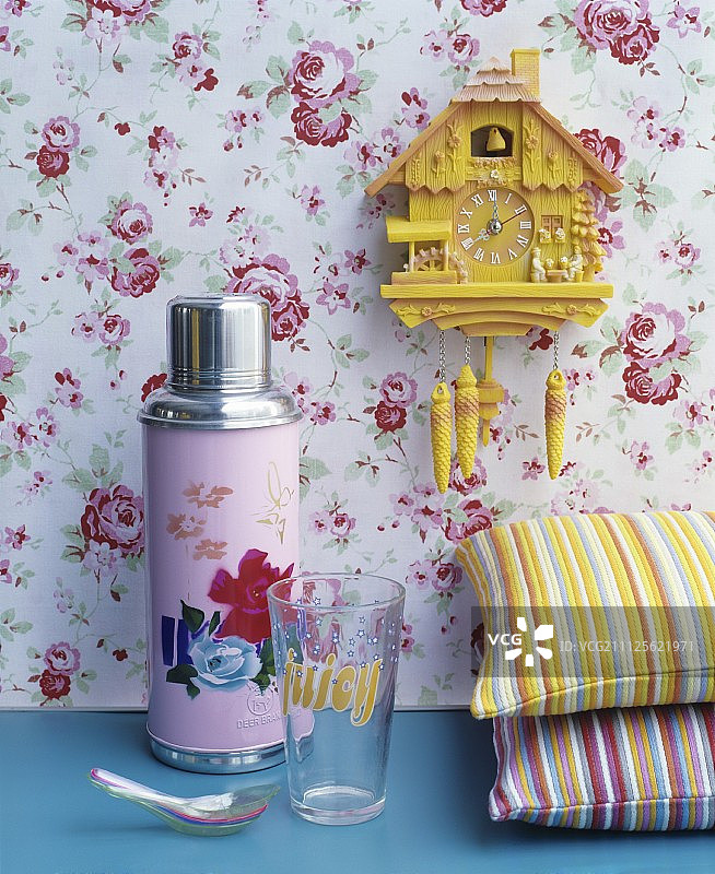 粉色热水瓶，花卉图案，明亮条纹靠垫，黄色布谷鸟钟，玫瑰图案壁纸图片素材