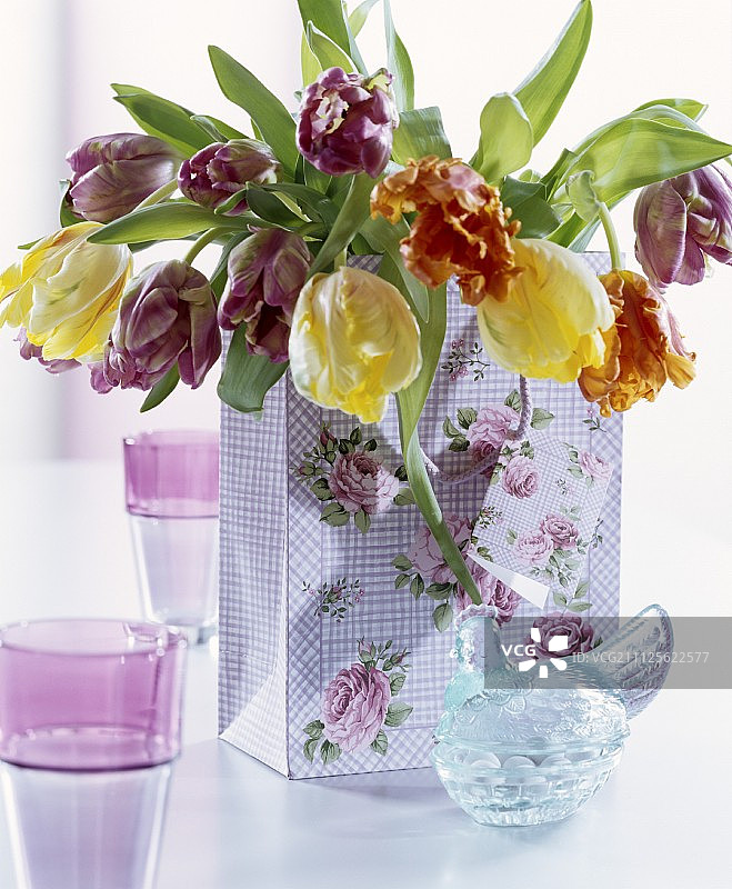 玫瑰图案礼品袋和复古风格母鸡造型玻璃罐中的郁金香花束图片素材