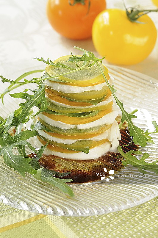 黄色和橙色番茄、马苏里拉奶酪和罗勒千层饼图片素材