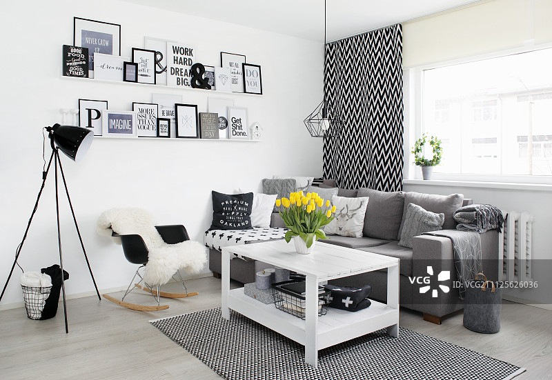 黑白客厅一角，木桌、灰色沙发和带框信息图片素材