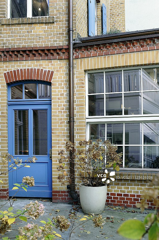 带有蓝色门和工业风格窗户的砖砌外墙图片素材