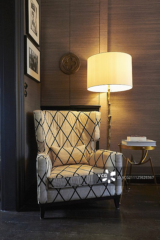 落地灯和黄铜边桌旁的舒适阅读椅图片素材