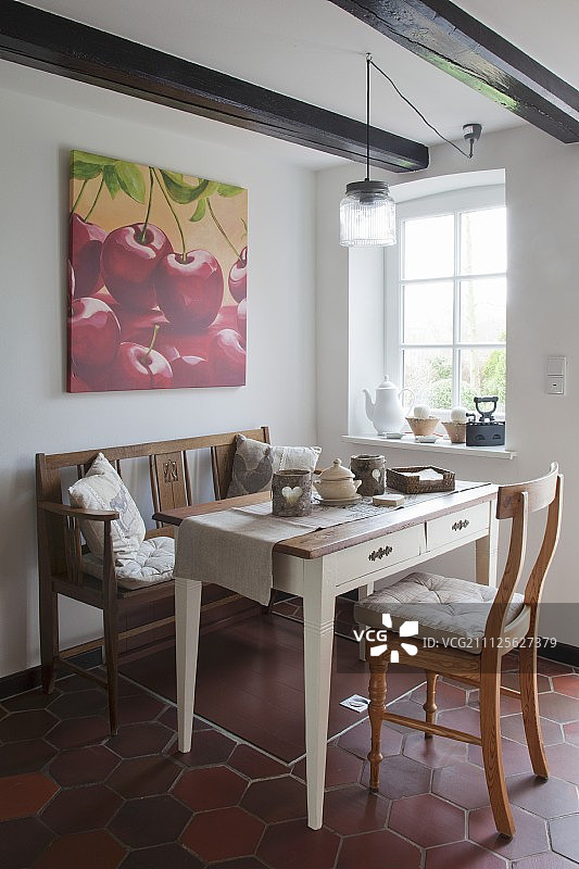 翻新农舍中赤陶地砖上的传统木制家具与活板门图片素材