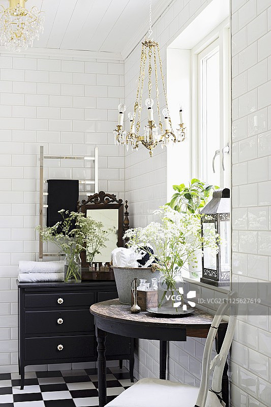 窗户下的控制台桌和浴室里的黑色抽屉柜，白色地铁墙砖图片素材