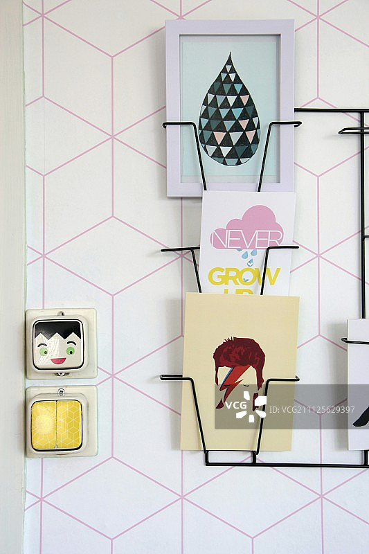 墙上的精致黑色杂志架，配有几何粉色图案壁纸图片素材