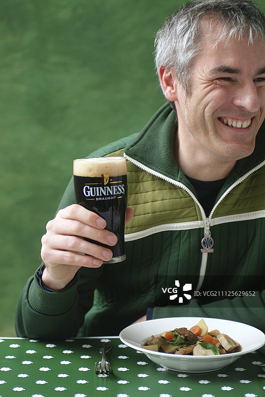 男人拿着一杯吉尼斯啤酒图片素材
