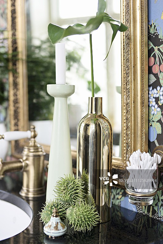 复古烛台、黄铜色花瓶中的叶子和带刺的水果图片素材