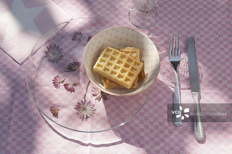 玻璃盘下的星辰花与碗中华夫饼图片素材