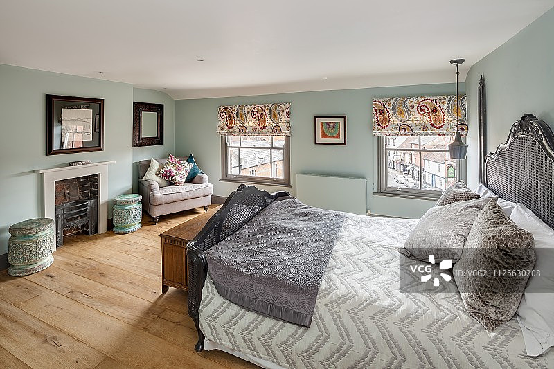 卧室里开放式壁炉和格子窗旁的扶手椅，具有复古氛围图片素材