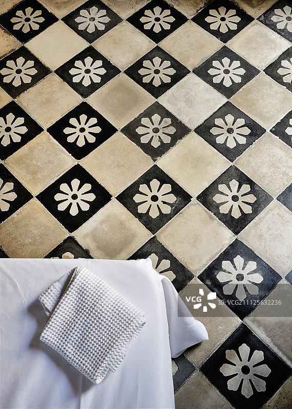 带有黑色瓷砖上白色花朵的传统格子瓷砖地板图片素材