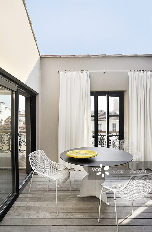 屋顶露台上的设计师桌子和金属椅子图片素材