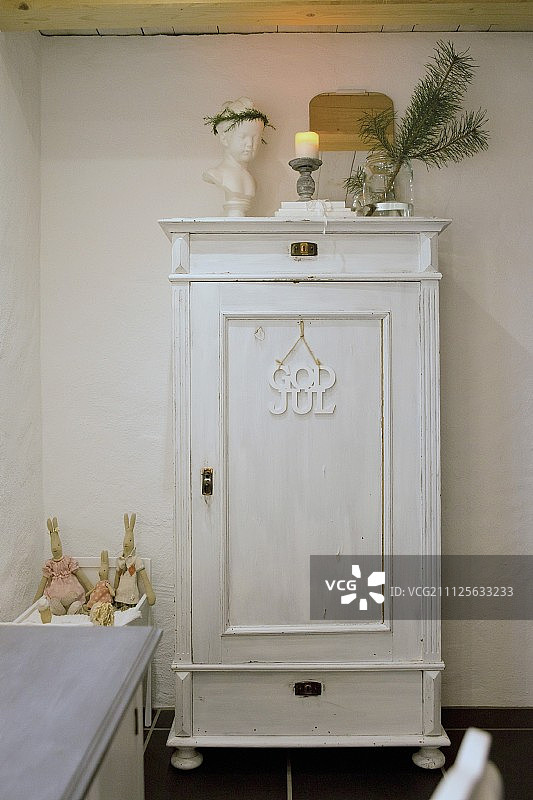 白色复古风格木制橱柜上的圣诞装饰品图片素材