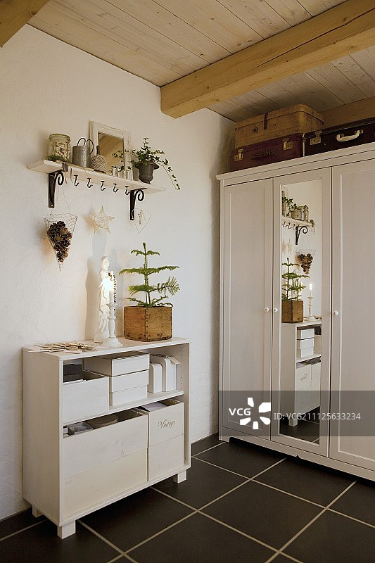 房间角落里，复古氛围中的绿色小针叶树旁的圣母雕像图片素材