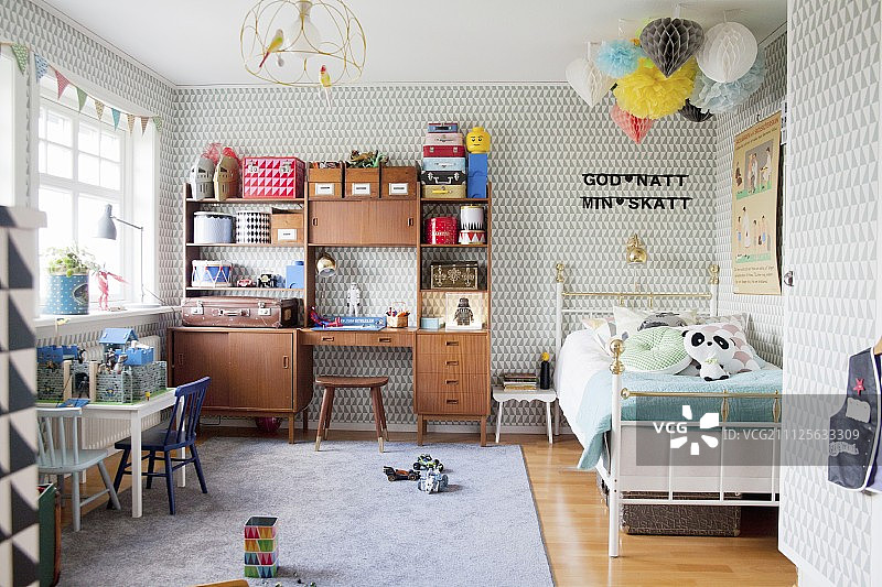 斯堪的纳维亚复古风男孩卧室：图案壁纸、玩具和复古柜图片素材