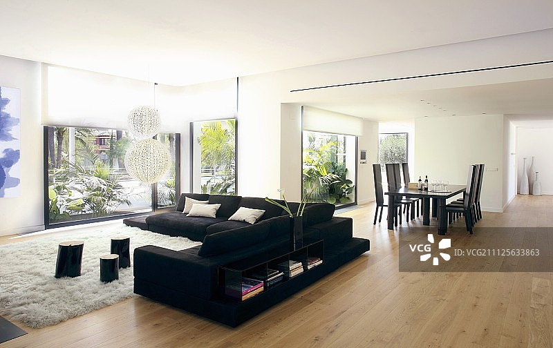 现代开放式室内设计中的餐桌和黑色沙发图片素材