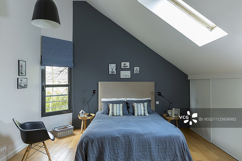 阁楼房间里的蓝色床罩双人床图片素材