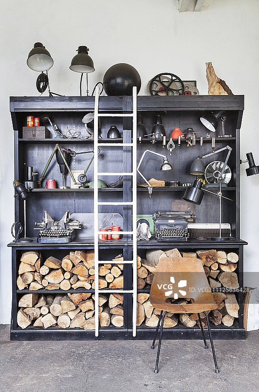 黑色书架上的老式台灯、打字机和木柴图片素材