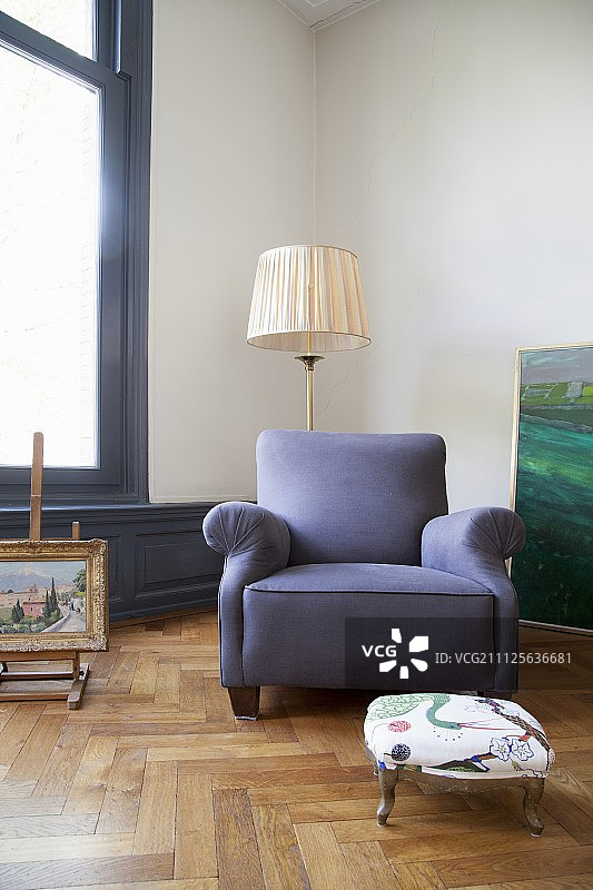 蓝色扶手椅和复古落地灯，位于公寓的橡木镶木地板上图片素材