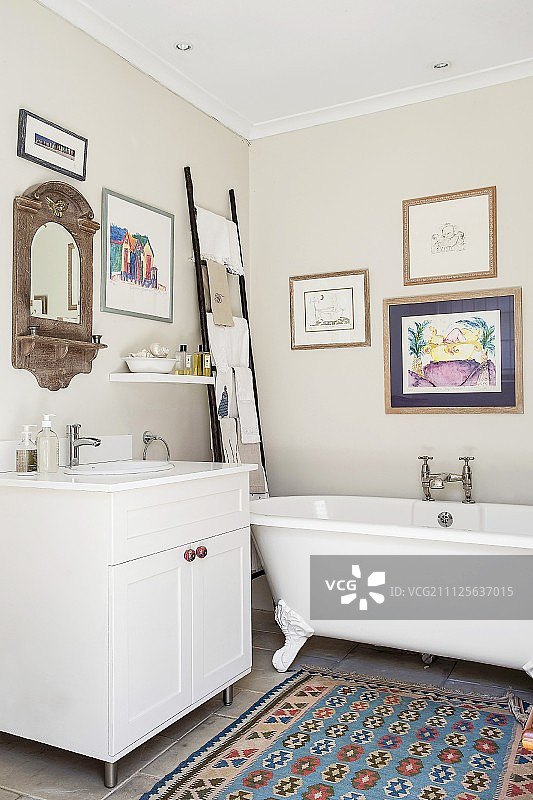 浴室中的独立式浴缸和梯子毛巾架图片素材