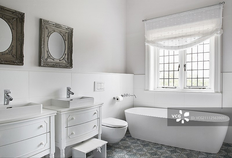 独立式浴缸和两个改造成盥洗台的旧抽屉柜图片素材