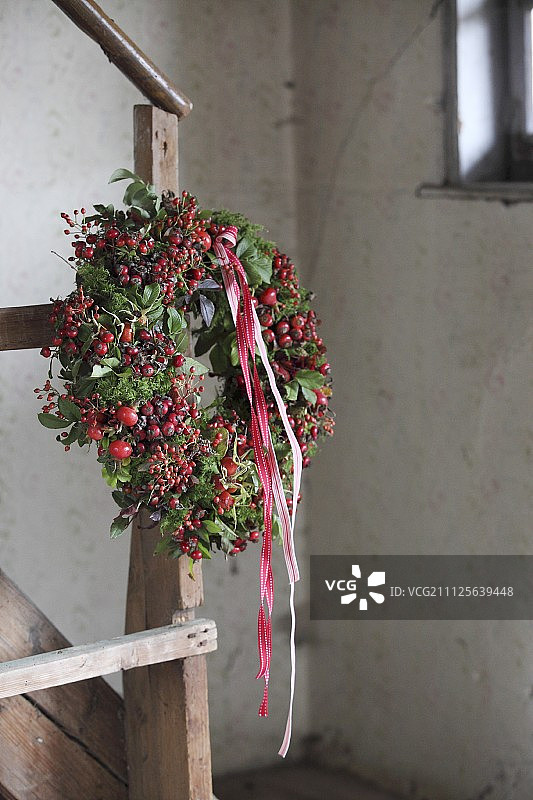 秋季花环：蔷薇果、苔藓与红白丝带图片素材