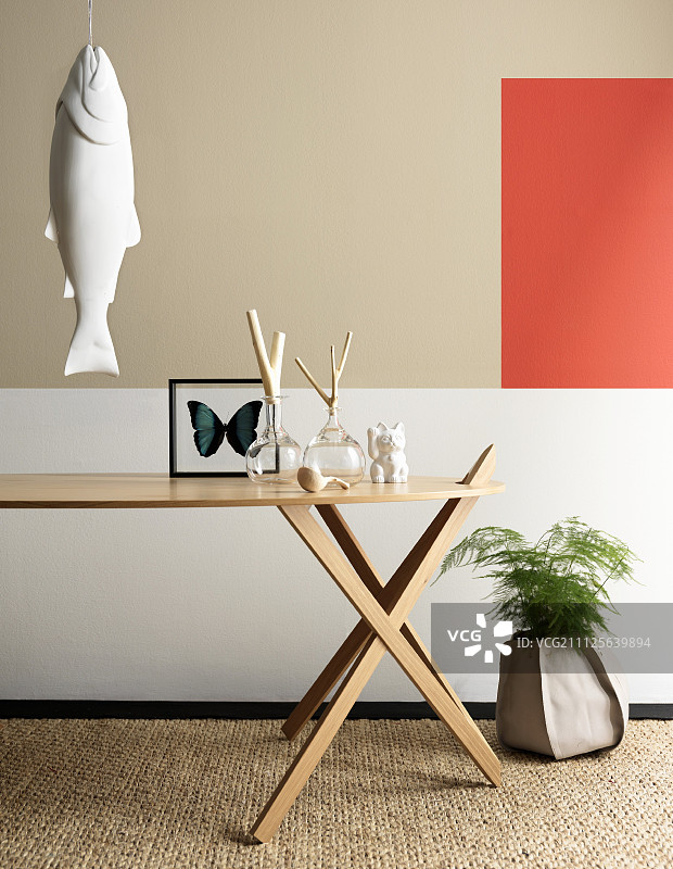 设计师桌子上的装饰品，墙上悬挂的鱼雕塑和墙上的彩色点缀图片素材