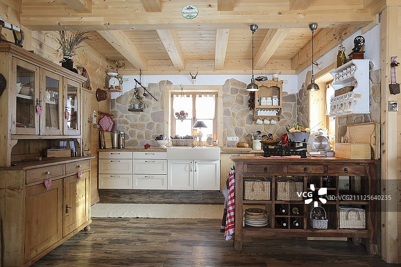 木屋开放式厨房内的梳妆台、岛台和一面石墙图片素材
