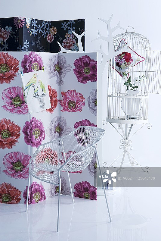 花卉面料屏风、白色金属设计师椅、衣架和鸟笼图片素材