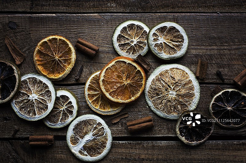 木质表面上的干柑橘片和肉桂棒图片素材