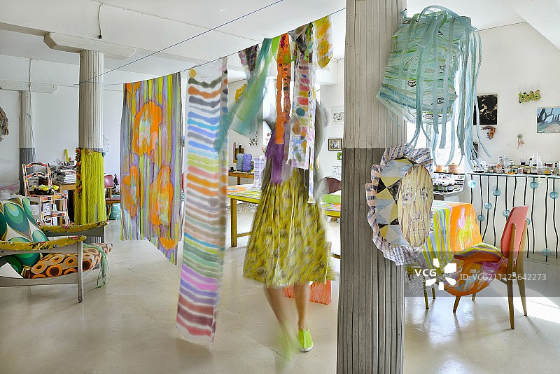 女子在阁楼公寓的晾衣绳上悬挂布料图片素材