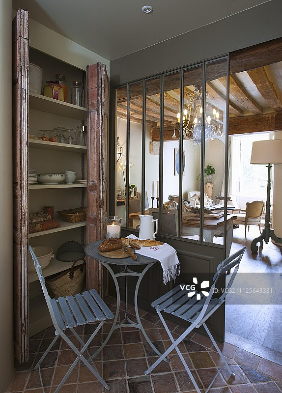 小酒馆餐桌上的面包和折叠椅，橱柜前是起居区的枝形吊灯视野图片素材