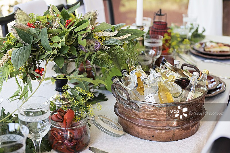 复古浴缸中的各种饮品、小龙虾和花卉摆件图片素材