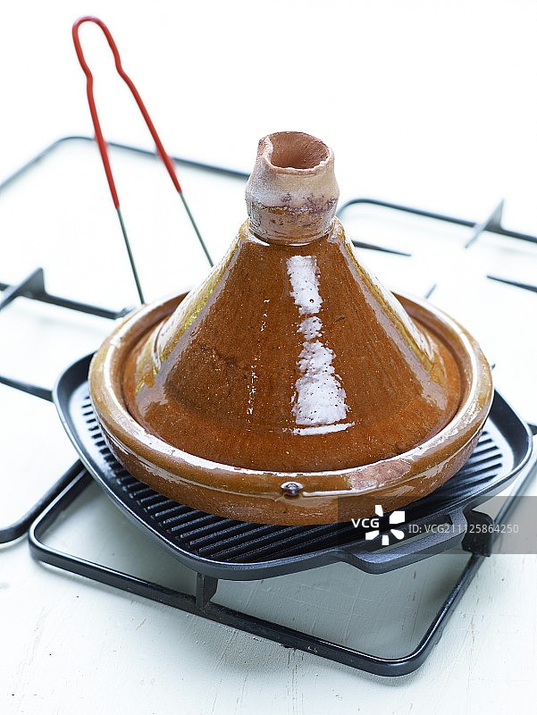 燃气灶烤盘上的塔吉锅图片素材