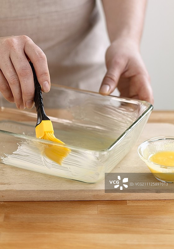 用刷子在盘子上涂黄油图片素材