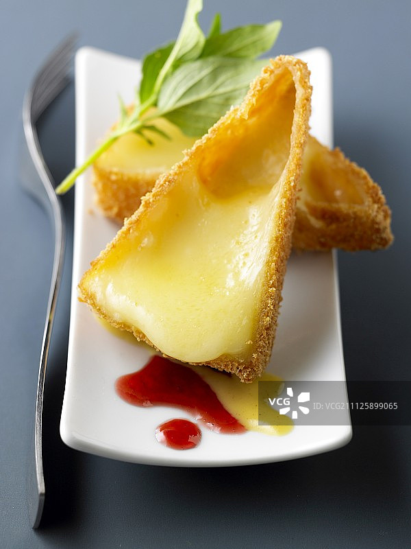 裹面包屑的热布里奶酪配红醋栗酱和蜂蜜酱图片素材