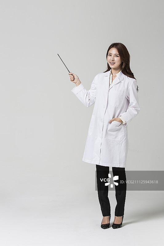 穿着医生袍子的女人拿着指示棒图片素材
