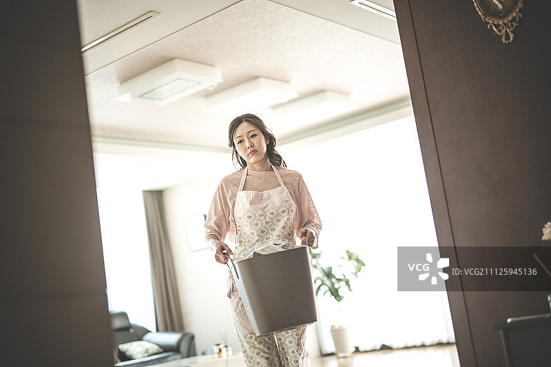 手提装满衣服的洗衣篮的女人图片素材