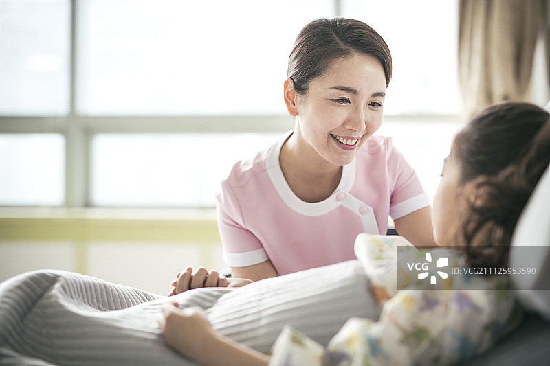 护士与病床上的女孩交谈图片素材
