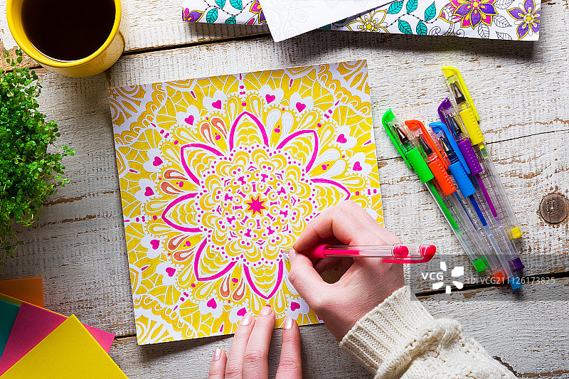 女人给成人涂色书上色，缓解压力图片素材