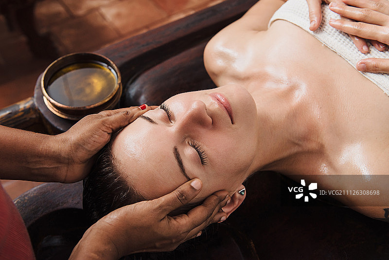 木桌上的阿育吠陀面部精油按摩图片素材