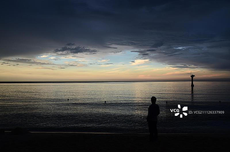 落日时分海边站立的男人剪影图片素材