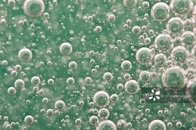 绿色背景下水中氧气泡的微距图片素材