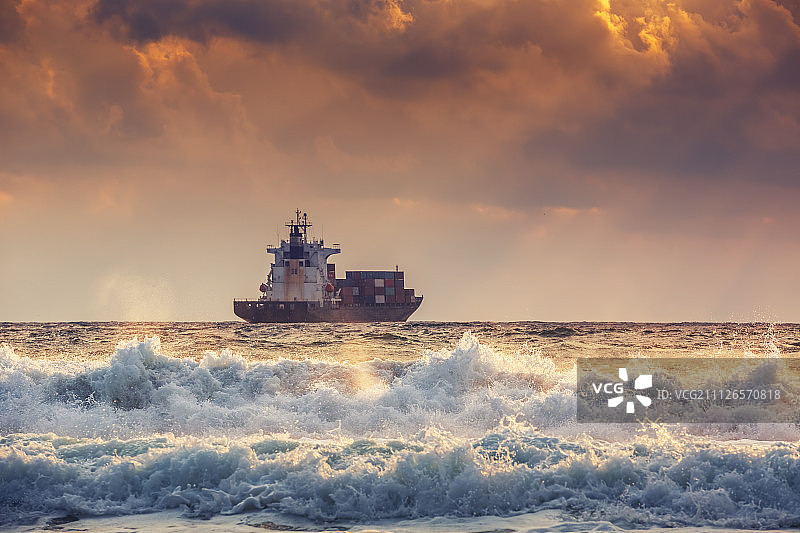 日出光芒下的集装箱货船图片素材