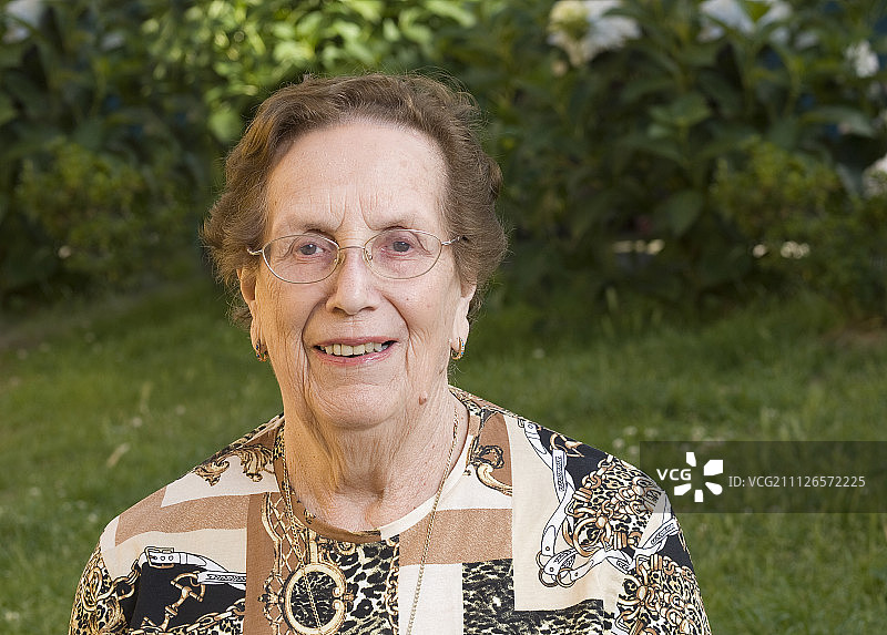 戴着眼镜，露出牙齿微笑的老年妇女图片素材