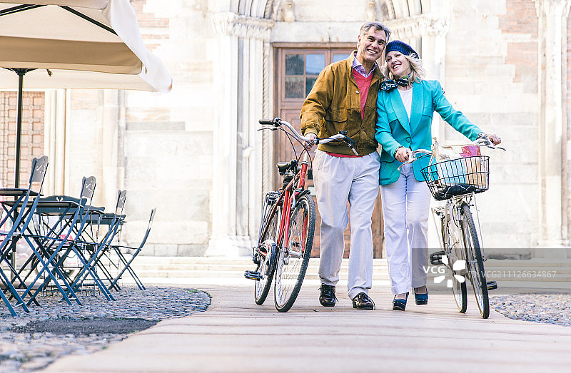年长夫妇在市中心推着自行车散步图片素材