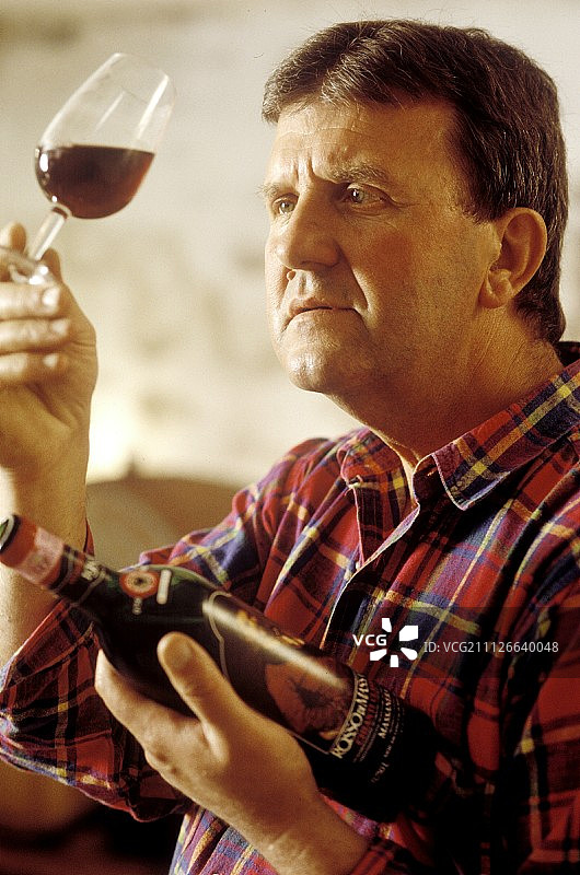 葡萄酒种植者卡洛·卡塔内奥检查他的基安蒂的颜色图片素材