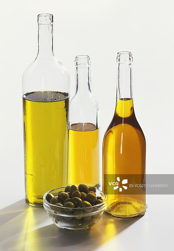 三瓶橄榄油和绿色橄榄图片素材